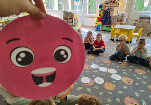 Prezentacja dużej kropki papierowej na tle dzieci