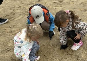 Dzieci szukają śmieci na pobliskiej plaży miejskiej