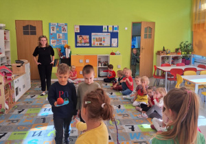 Dzieci przenoszą jabłka na talerzykach