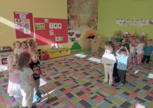 Dzieci stoja w kolorowych obręczach