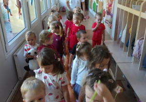 Dzieci ida korytarzem przedszkolanym w parach