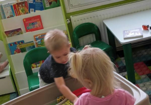 Dwoje dzieci bawi się przy torze samochodzikami