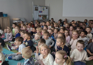 Dzieci siedzą i oglądają w skupieniu przedstawienie