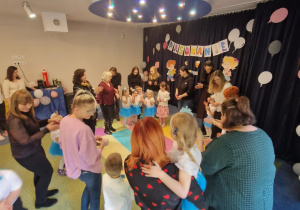 Dzieci bawią się wraz z rodzicami przy muzyce