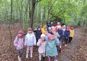 Dzieci stoją w grupie na ścieżce leśnej