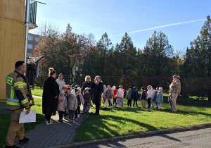 Dzieci z grupy "Biedronki" stoją w obecności swoich opiekunów
