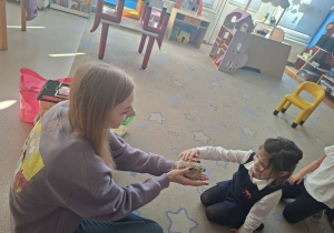 Dziewczynka z uśmiechem głaszcze jeża