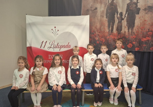 Dzieci z grupy "Sowy" pozują na tle symboli narodowych