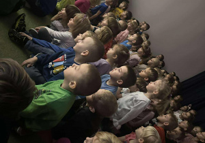 Dzieci siedzą i oglądają przedstawienie