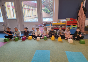 dzieci wystukują rytm na plastikowych pojemnikach