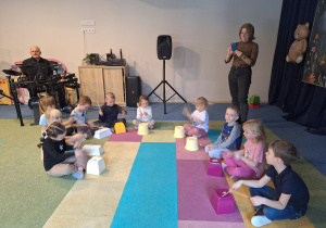 dzieci wystukują rytm na plastikowych pojemnikach