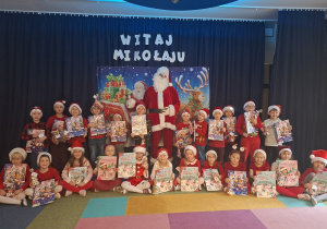Grupa "Sowy" pozują do zdjęcia ze Św.Mikołajem
