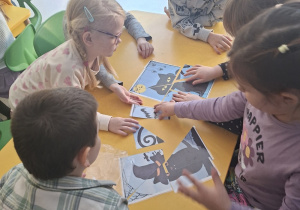 Dzieci układają puzzle związane z andrzejkami