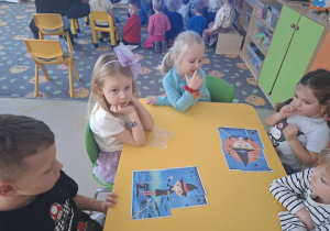 Dzieci układają puzzle związane z andrzejkami