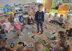 Chłopiec stoi na środku koła i losuje przedmiot związny z zawodem