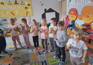 Dzieci stoją obok siebie trzymajac w ręku obrazek wybranego zwierzątka