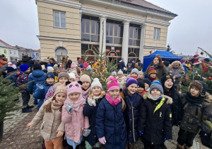 Dzieci stoją wokół choinki