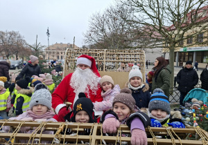 Kilkoro dzieci siedzi w saniach ze Św. Mikołajem
