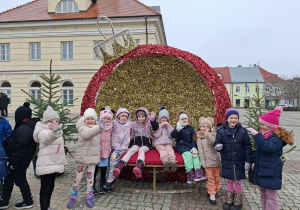 Dziewczynki stoją na tle świątecznej dużej bombki