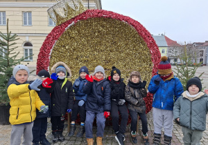 Chłopcy stoją na tle świątecznej dużej bombki