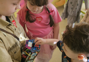 Dzieci wrzucają pieniądze do puszki