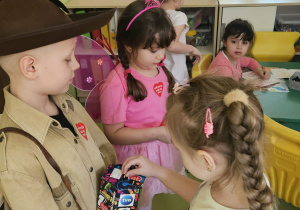 Dzieci wrzucają pieniądze do puszki