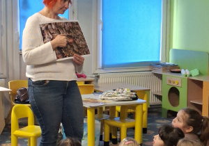 Prowadząca pokazuje zdjęcie pszczół