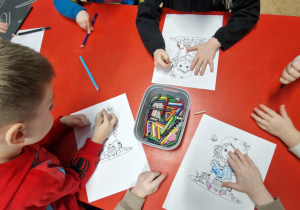 Dzieci kolorują obrazki z bohaterami