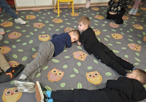 Dzieci układają z własnych ciał kształt trójkąta