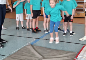 Dziewczynka skacze z miejsca na materac