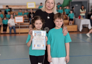 Dziewczynka z chłopcem i p.dyrektor pozują po odebraniu dyplomu