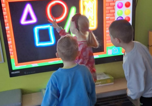 Dziewczynka rysuje wybrane kształty