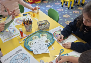 Dzieci kolorują i naklejają wycięte zdrowe produkty