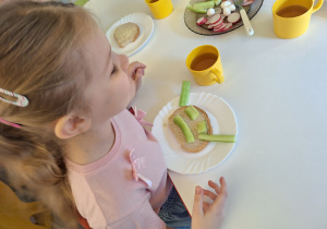 Dziecko układa obrazek na swojej kanapce z warzyw