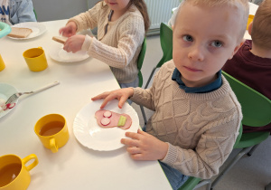 Dziecko układa obrazek na swojej kanapce z warzyw