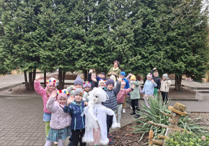 Dzieci z Marzanną stoją przed przedszkolem