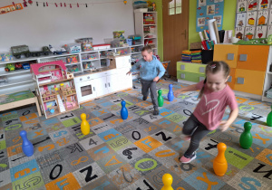 Dzieci biegną wokół kręgli