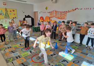 Dzieci skaczą przez obręcze