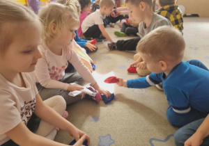 Dzieci podają woreczki w rytm muzyki