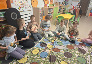 Kilkoro dzieci z sylwetami produktów do segregacji