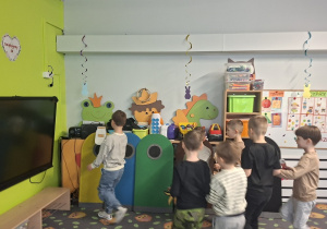 Dzieci wrzucają odpady do właściwych pojemników