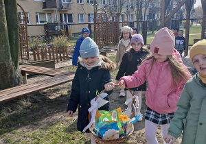 Dzieci w ogrodzie z koszykiem od zajączka