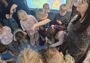 Dzieci usypują górę z zebranych monet