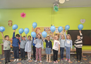 Grupa dzieci z niebieskimi balonami