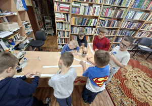 Dzieci przy stolikach kolorują korony