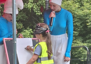 Dziewczynka na scenie maluje portret smerfa
