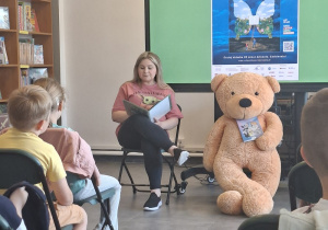 Pani z biblioteki czyta dzieciom bajkę