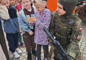 Kilkoro dzieci ogląda broń żołnierską