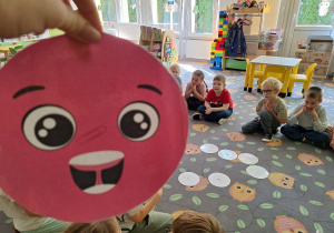 Prezentacja dużej kropki papierowej na tle dzieci