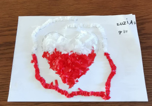 Praca przedstawia serce biało-czerwone wyklejone bibułą